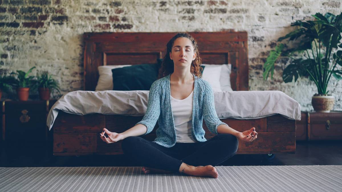 Woman practicing yoga at sunrise with journal and herbal tea, illustrating natural ways to balance hormones